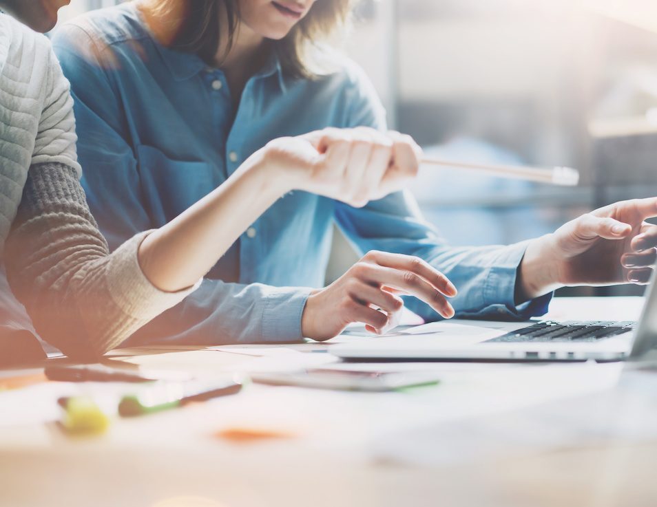 Coworkers photo in modern office.Project manager team work new idea.Young business crew working with startup.Laptop computer on table,showing presentation.Blurred,film effect.Horizontal